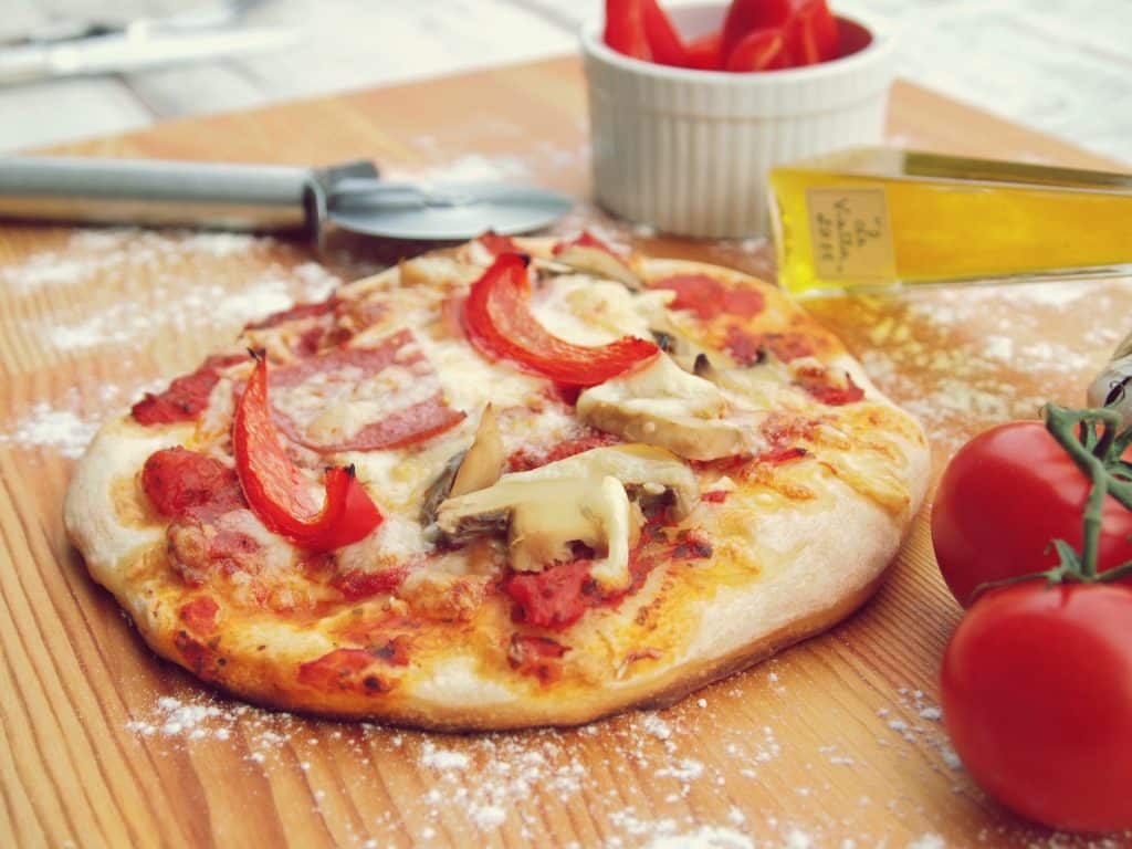 Imagem de uma linda e saborosa pizza de cogumelo com queijo e tomates.
