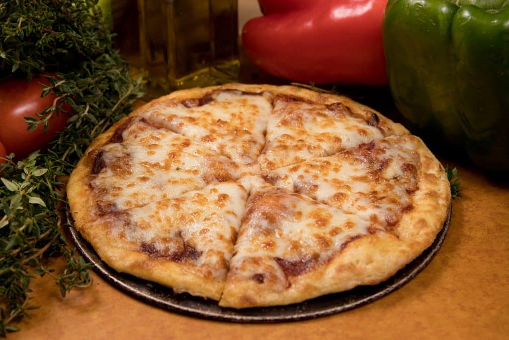 Imagem de uma linda e saborosa pizza de 4 queijos já assada e pronta para ser apreciada.