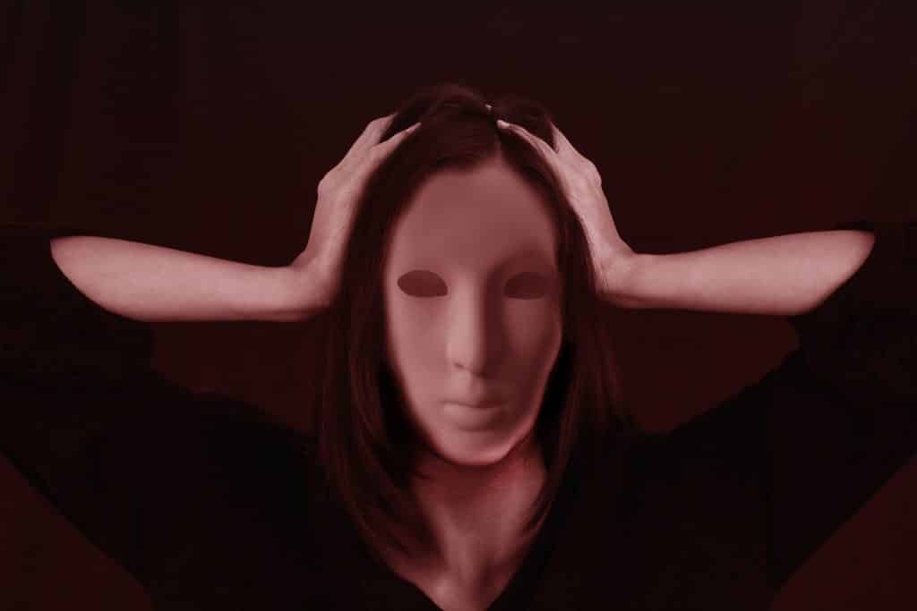 Imagem do rosto de uma mulher sendo coberto por uma máscara.