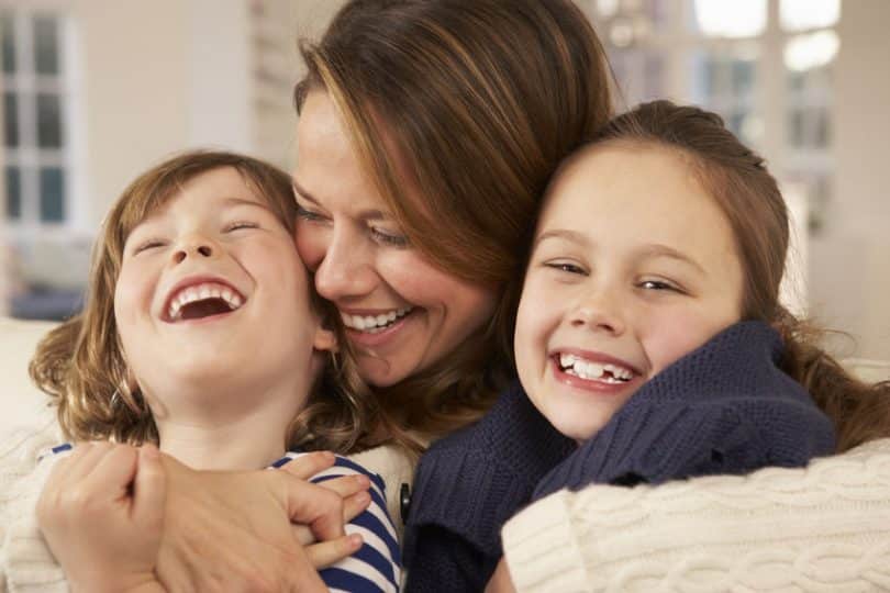 Mãe abraçando filhos