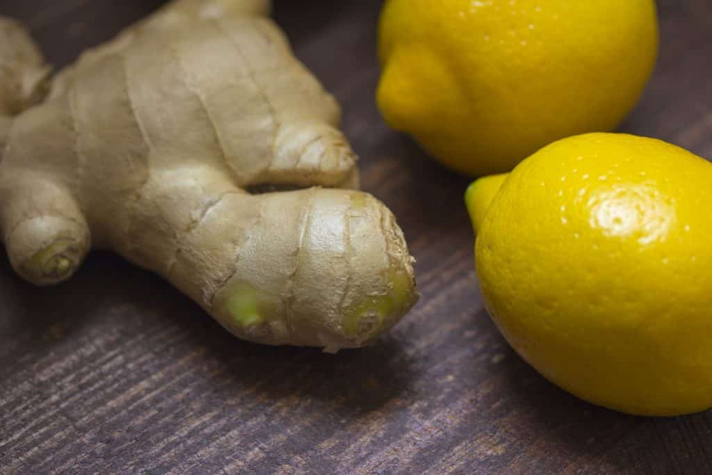 Imagem de um gengibre e dois limões, ingredientes para o preparo da água com gengibre.
