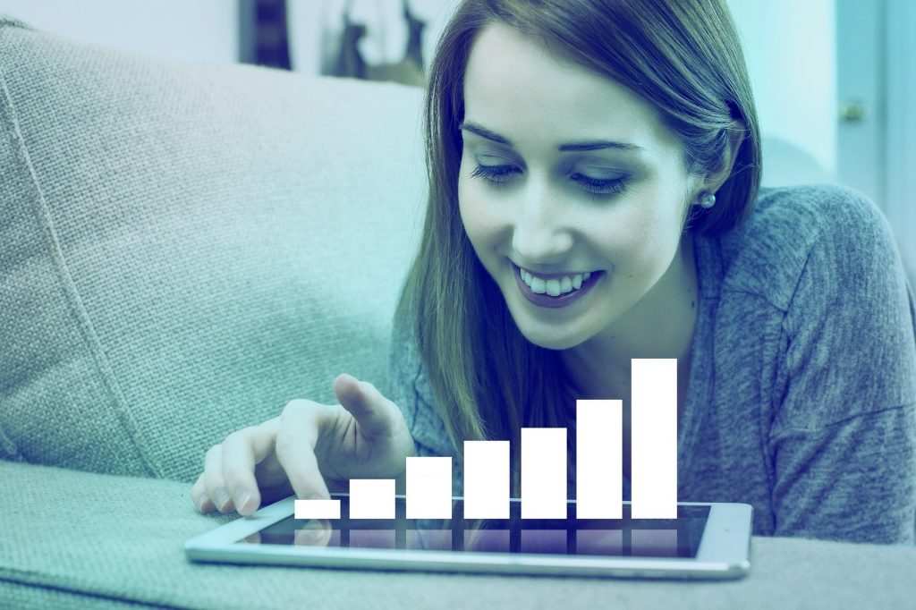 Imagem de uma mulher empreendedora usando o seu tablet para analisar os gráficos de suas finanças.