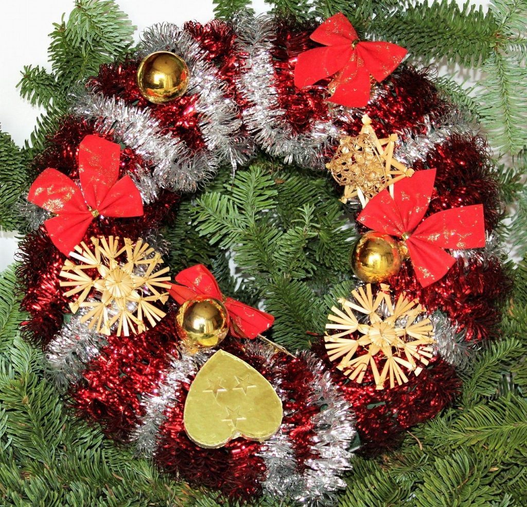 Imagem de uma linda guirlanda de natal feita nas cores verde, vermelha, branca e com enfeites dourados.
