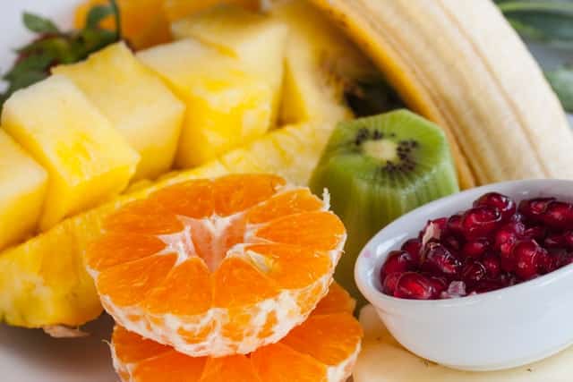 Laranja, abacaxi, kiwi e romã para salada de frutas vista de perto