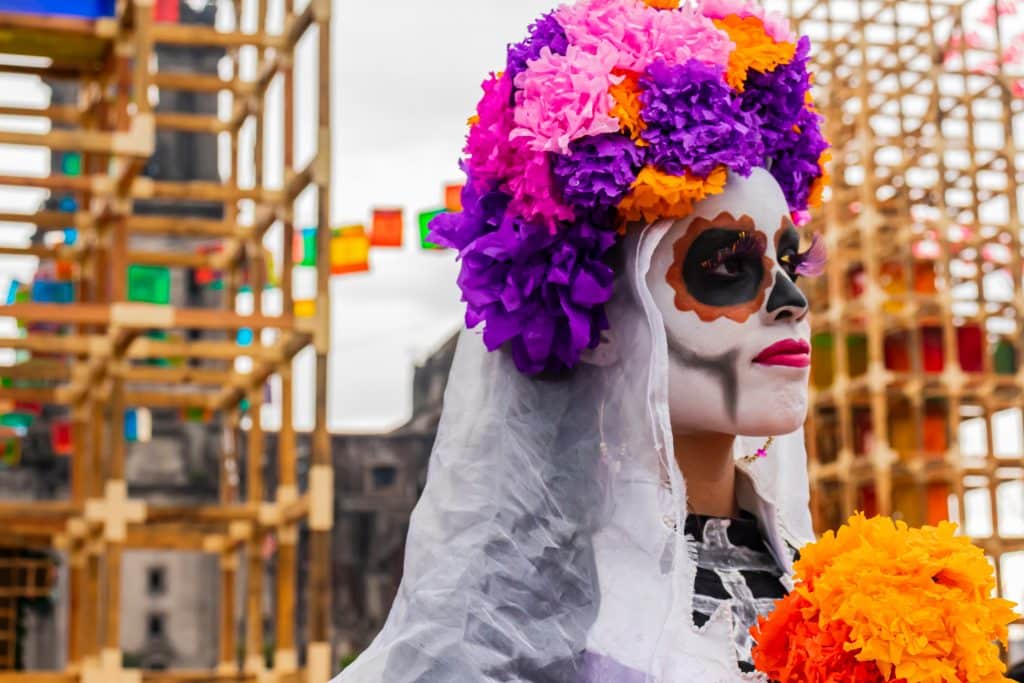 Mulher com rosto pintado de caveira e flores na cabeça