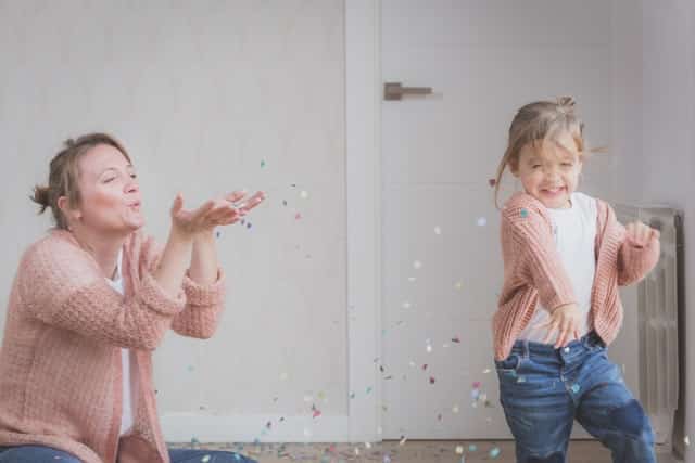 Mãe brincando com filha correndo sorrindo