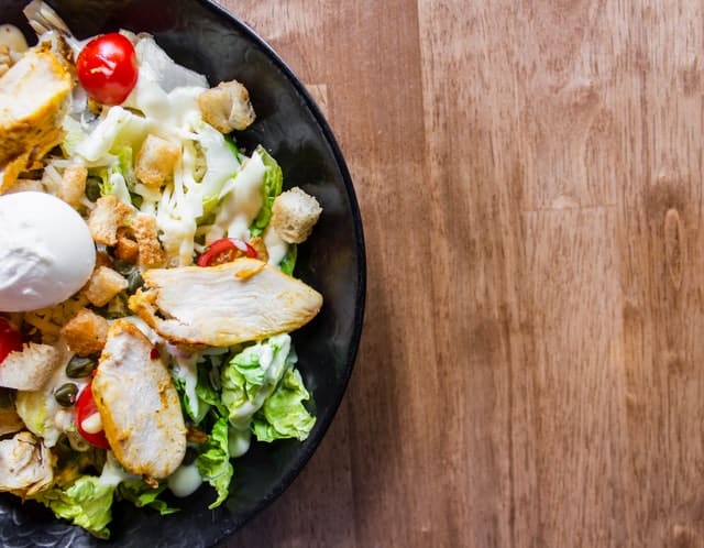 Prato com salada visto de cima em fundo de madeira