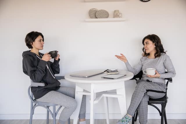 Mulheres em mesa tomando café e conversando