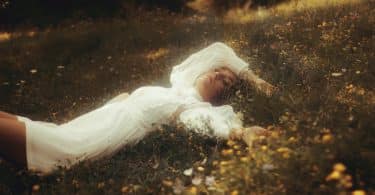Mulher deitada em um gramado usando vestido