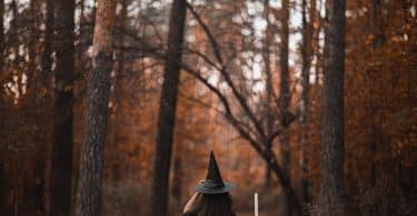 Mulher em uma floresta com roupas de bruxa