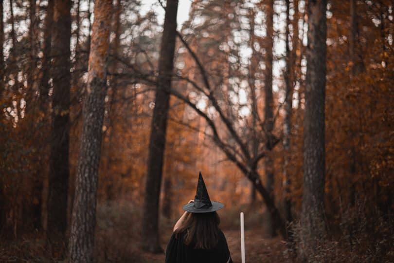 Mulher em uma floresta com roupas de bruxa