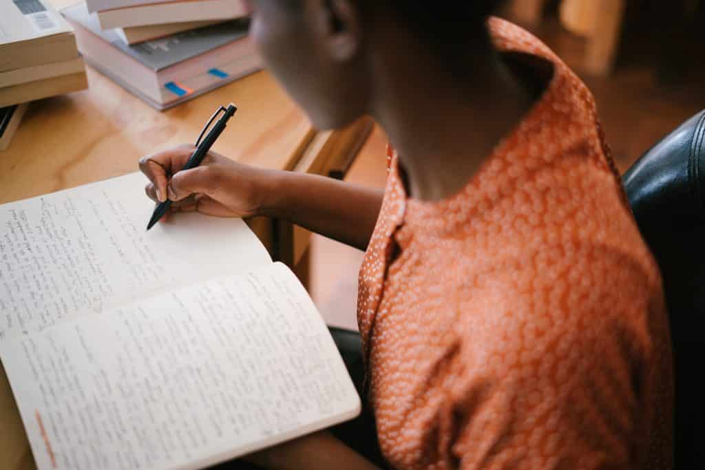 Mulher escrevendo em um caderno