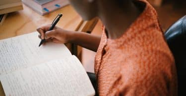 Mulher escrevendo em um caderno