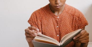 Mulher segurando um livro e lendo