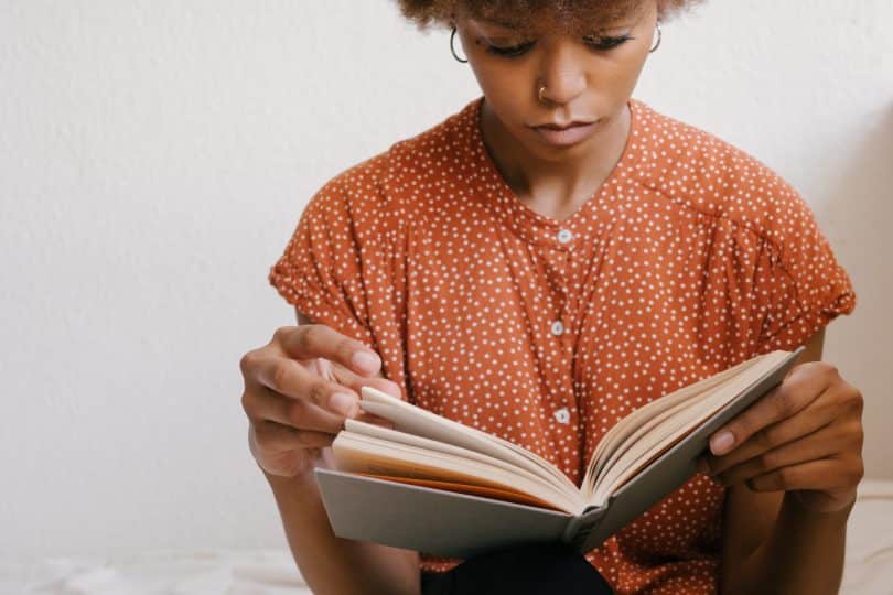 Mulher segurando um livro e lendo