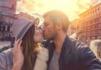 Casal tirando um selfie enquanto se beija