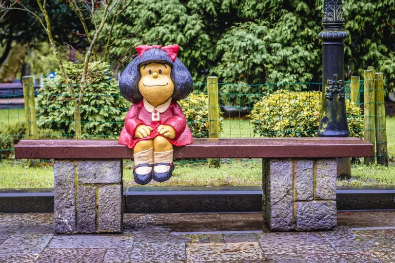 Estátua da personagem Mafalda criada por Pablo Irrgang. Ela está sobre um banco em um parque de Oviedo, na Espanha.