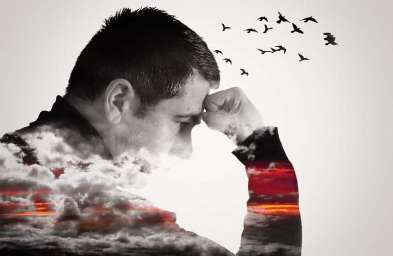 Imagem de um homem pensando com o punho erguido na testa. Nuvens cobrem seu peito e braços enquanto pássaros voam de sua cabeça.