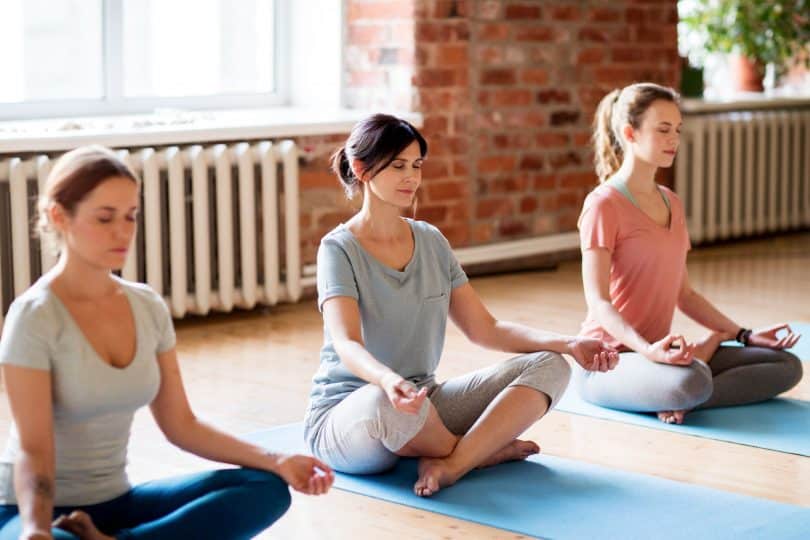 grupo de mulheres fazendo meditação