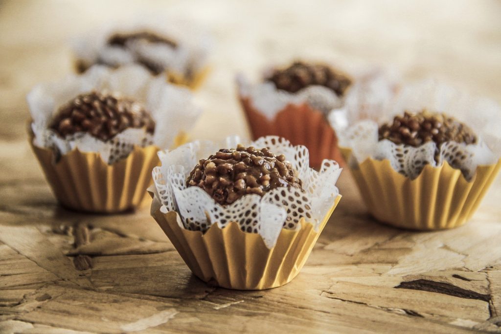 Imagem de uma mesa e sobre ela cinco brigadeiros feitos com batata-doce.
