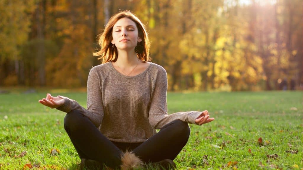 Mulher meditando na grama