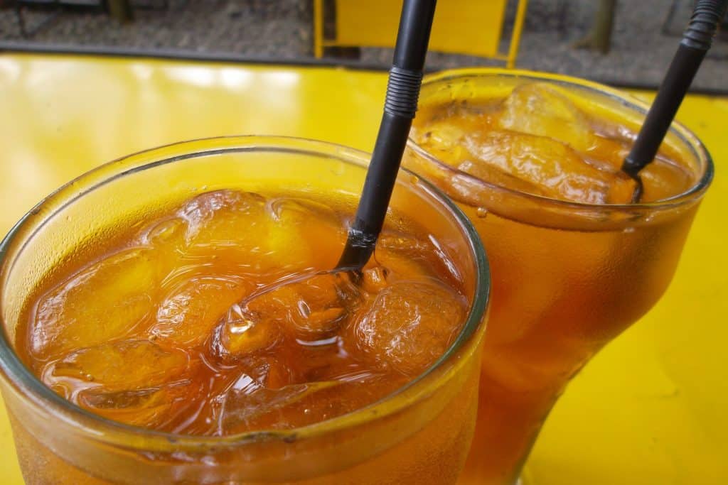 Imagem de dois copos de chá detox feito com gengibre e abacaxi servidos bem gelados.