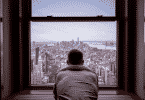 Figura de um homem olhando pela janela