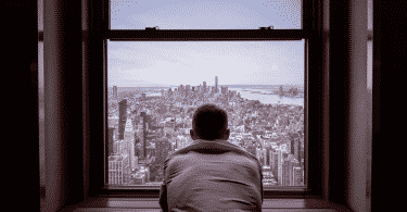 Figura de um homem olhando pela janela