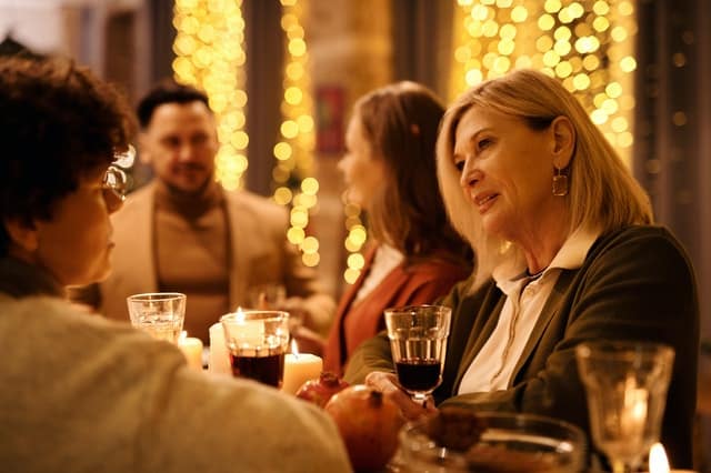 Senhora conversando em mesa de natal com família