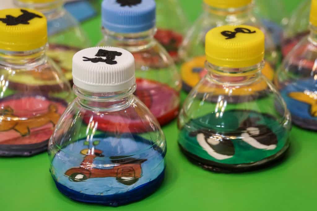 Imagem de um brinquedo reciclado feito de garrafa pet. São vários cofrinhos coloridos para guardar moedas.