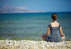 Mulher jovem sentada na praia desfrutando de um momento de paz