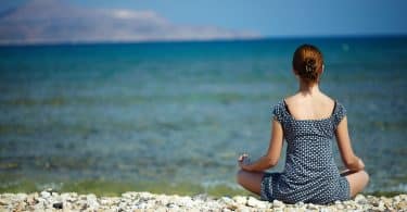 Mulher jovem sentada na praia desfrutando de um momento de paz