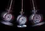 Imagem preto e branco de três relógios de pêndulos usados para serem usados em sessões de hipnoterapia.