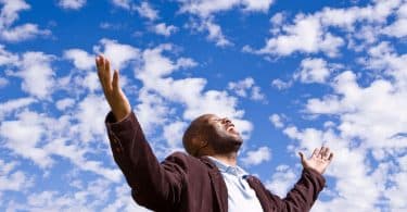 Homem feliz estendendo as mãos para o céu