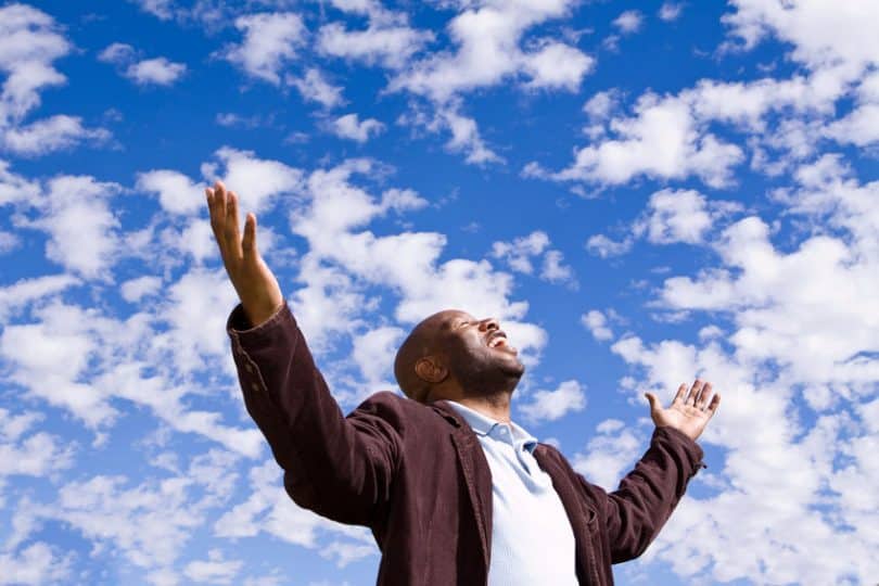 Homem feliz estendendo as mãos para o céu