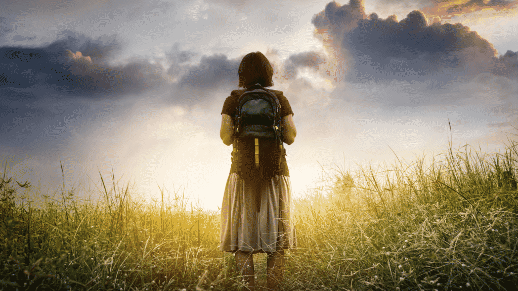 Menina em um campo com mochila na costa