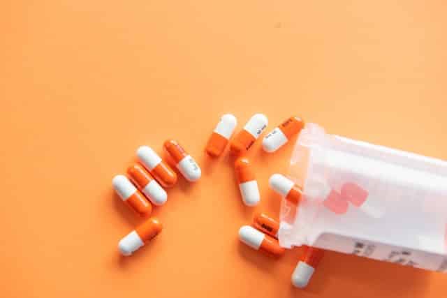 Pílulas brancas e laranjas.