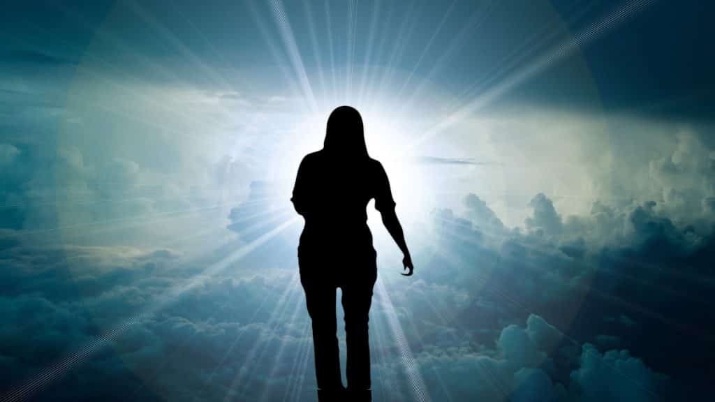 Imagem de uma mulher andando próximo às nuvens em direção ao céu.