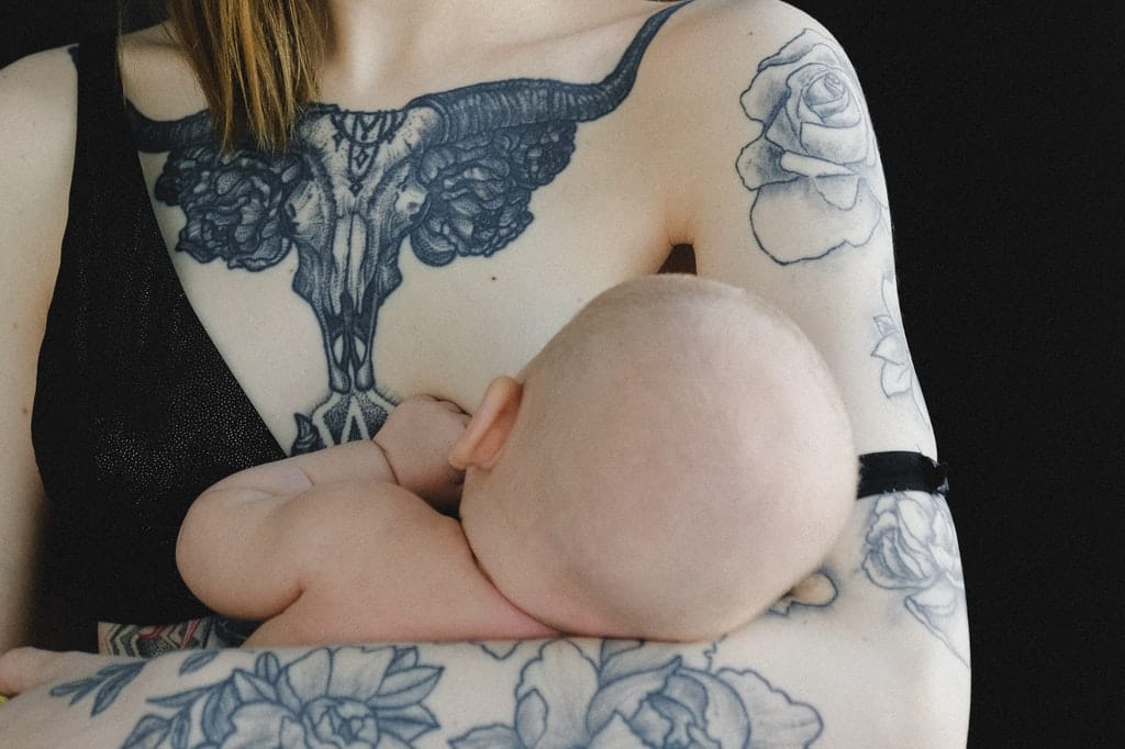 Bebê sendo amamentado pela mãe.