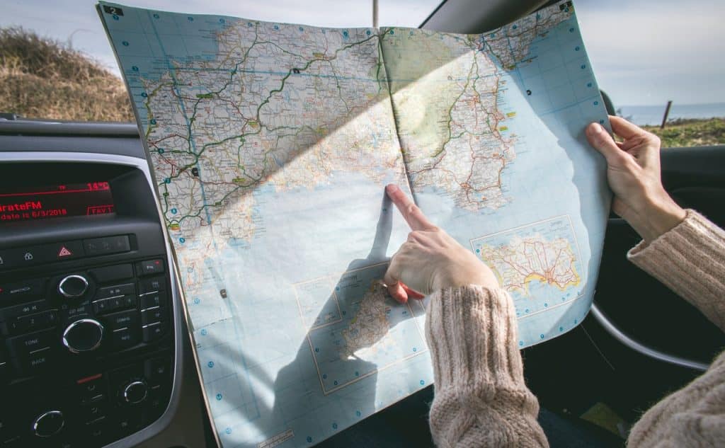 Menina apontando para um mapa dentro do carro