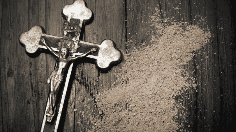 crucifixo ao lado de cinzas