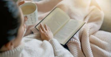 Mulher lendo livro na cama