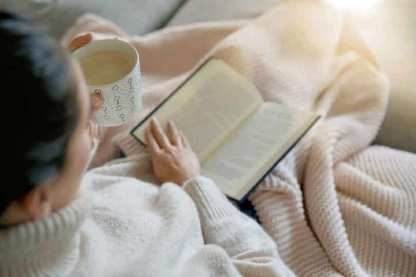 Mulher lendo livro na cama