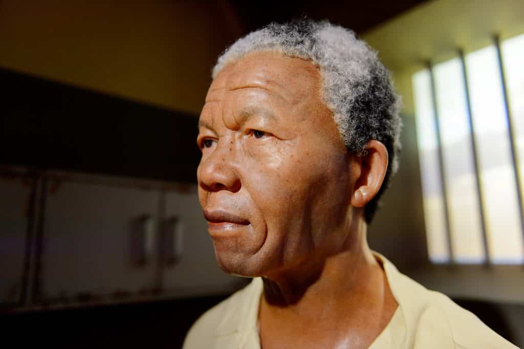 Imagem de perfil do rosto do ativista Nelson Mandela. Ele está na cela da prisão.
