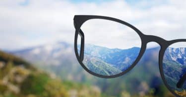 Visão da natureza pelo óculos com o fundo desfocado.