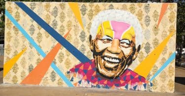 Imagem de um muro pintado com a imagem do rosto de Nelson Mandela. Trata-se de uma homenagem ao ativista.