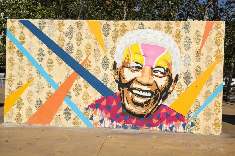 Imagem de um muro pintado com a imagem do rosto de Nelson Mandela. Trata-se de uma homenagem ao ativista.