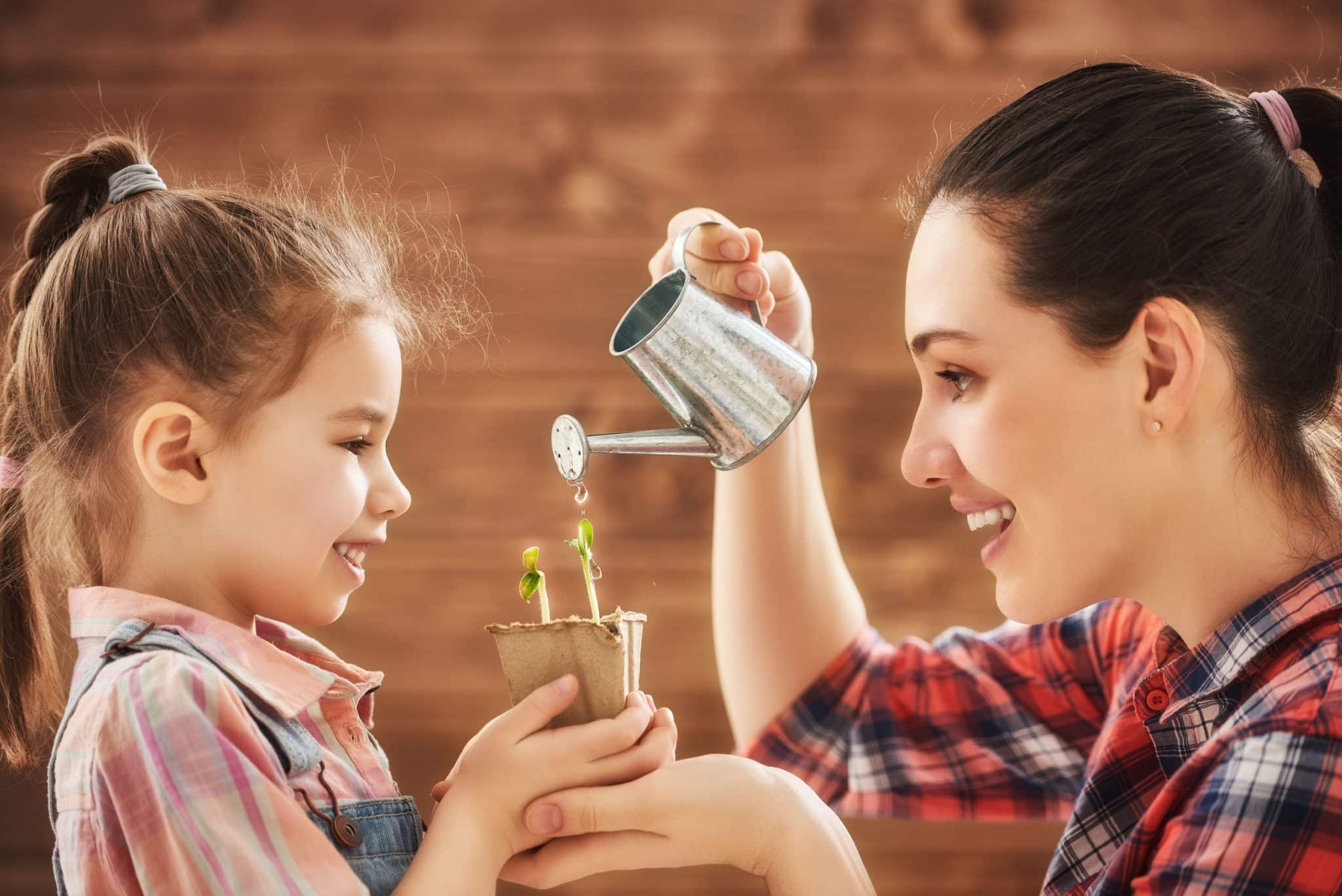 Mãe e filha regando planta