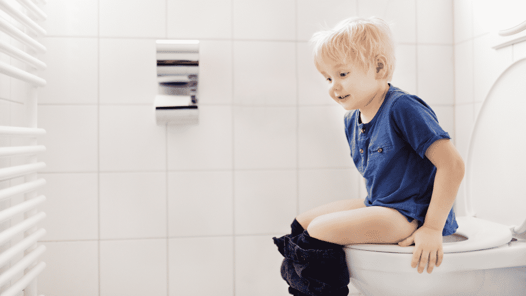 Criança sentada em vaso sanitário
