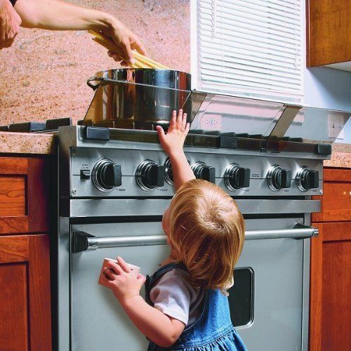 Criança tenta alcançar uma panela que está sobre o fogão.